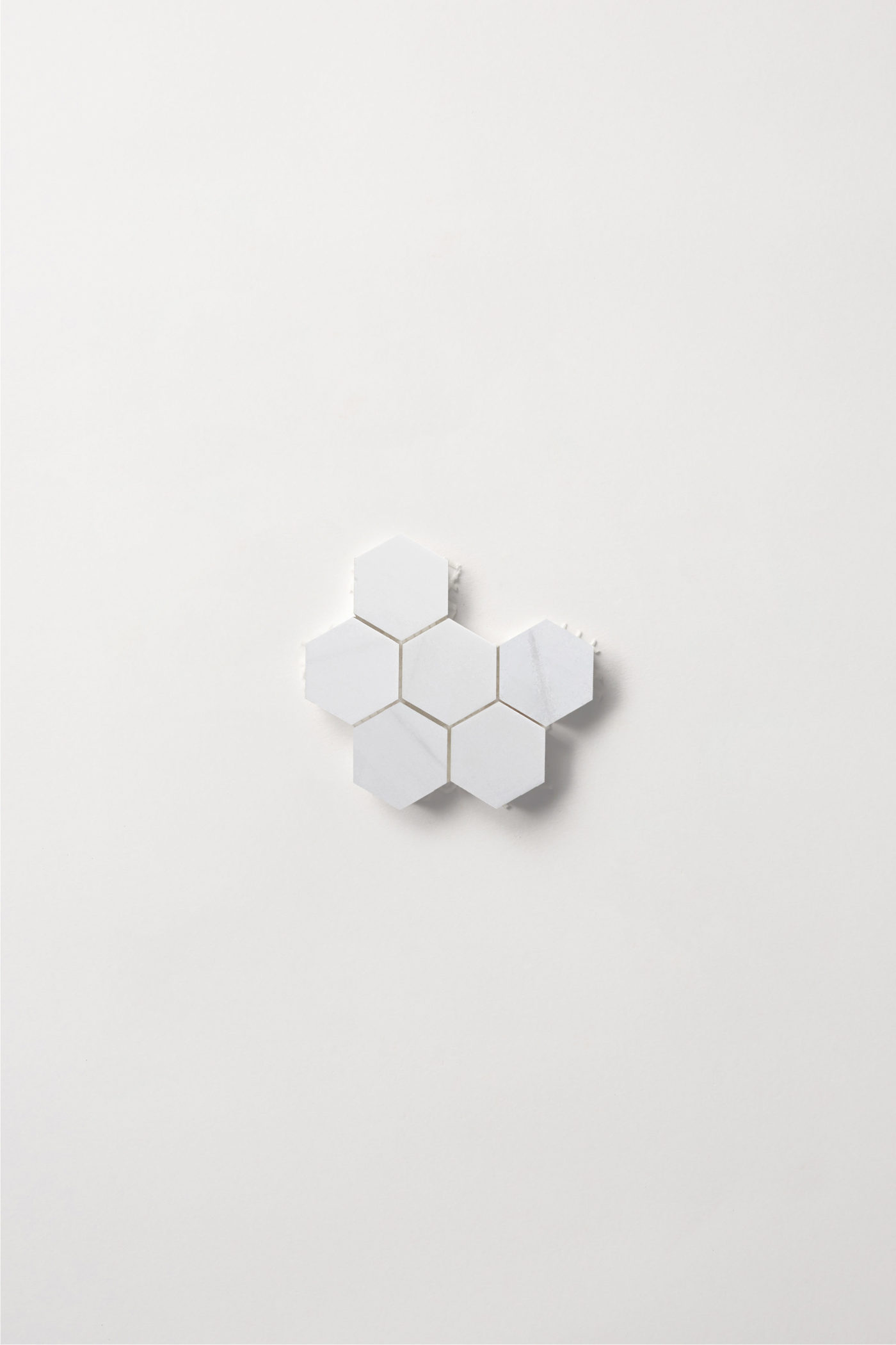 a sheet of small white hexagon tiles on a white background.