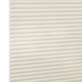 Off-white cellular (honeycomb) shade with evenly spaced horizontal pleats, lowered and closed, filtering soft light; textured linen-like fabric visible against a neutral bright background with no room details.