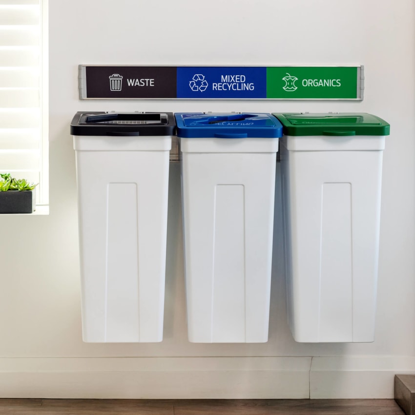 triple wall hanging waste and recycling containers with white bodies and colored lids in a modern office environment