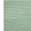 Mint-green honeycomb cellular blind with horizontal pleats and white hexagonal edges, fully closed, blocking view; close-up, flat-lit studio background, no room or window frame visible.