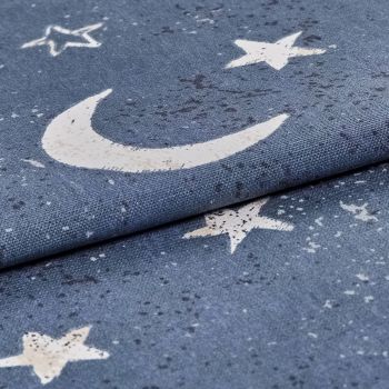 Blue woven curtain fabric printed with white crescent moon and stars, folded over itself with a distressed print, close-up macro view of textured textile under soft, neutral lighting.