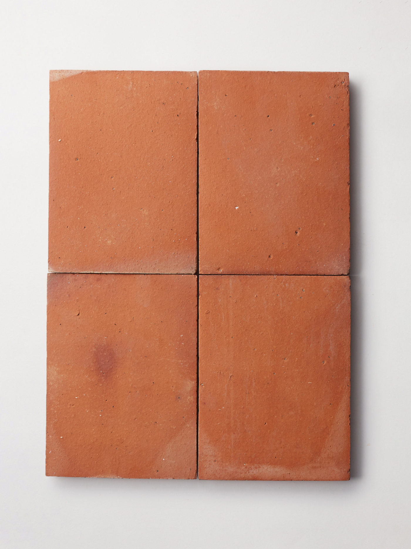 four red, rectangular clay tiles on a white background.