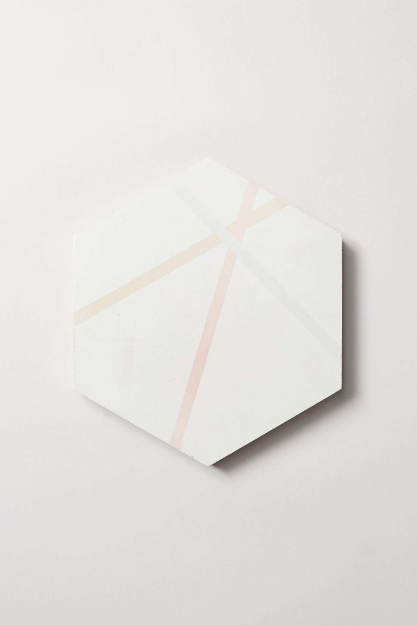 a white hexagonal tile with multicolored lines on a white surface.