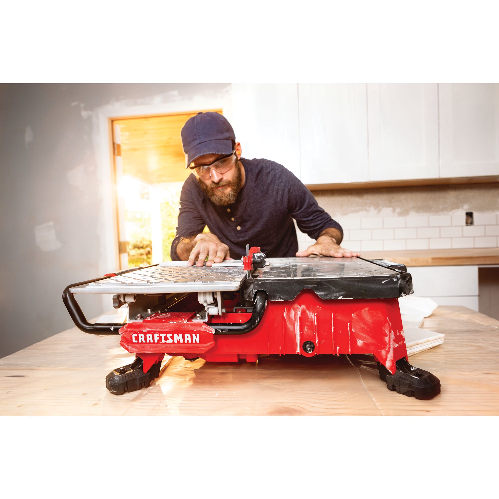 20 volt 7 inch cordless compact wet tile saw being used by a person to cut a tile.