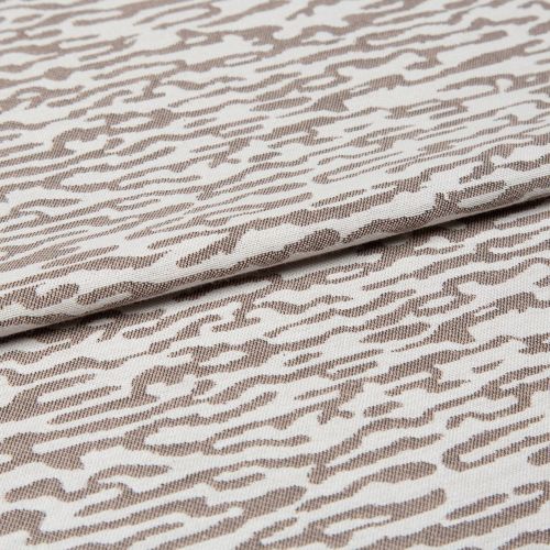 Decorative woven fabric with white and light beige abstract zebra-like pattern, tightly woven and folded across the center; lying as a layered textile sample in a close-up, evenly lit shot.