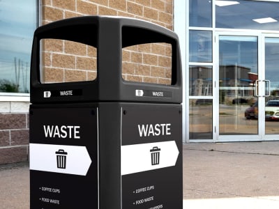 black trash container with a canopy lid outside of a hockey arena