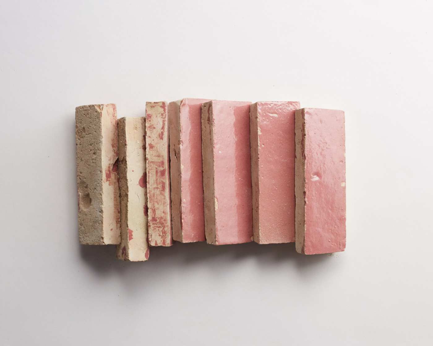 a stack of pink tiles on a white surface.