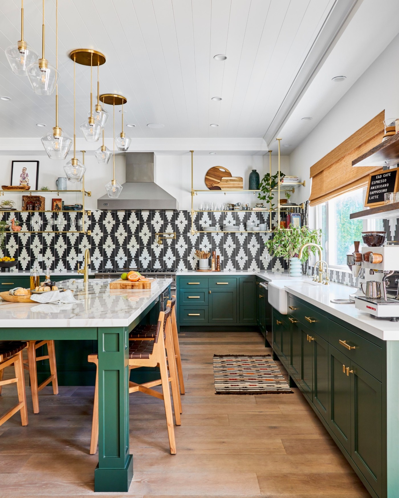 a kitchen with green cabinets and gold accents.