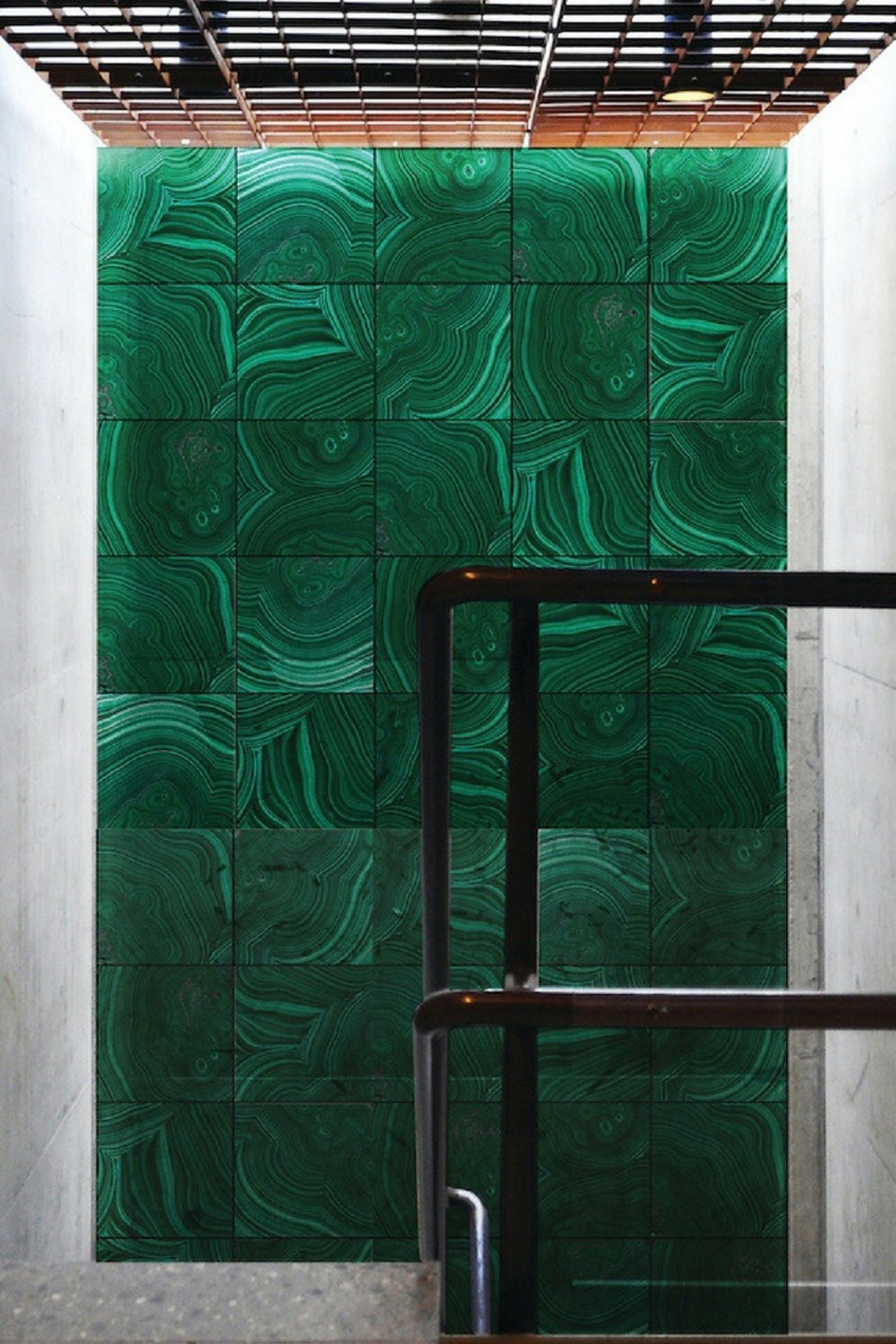 a green tiled wall in a concrete building.