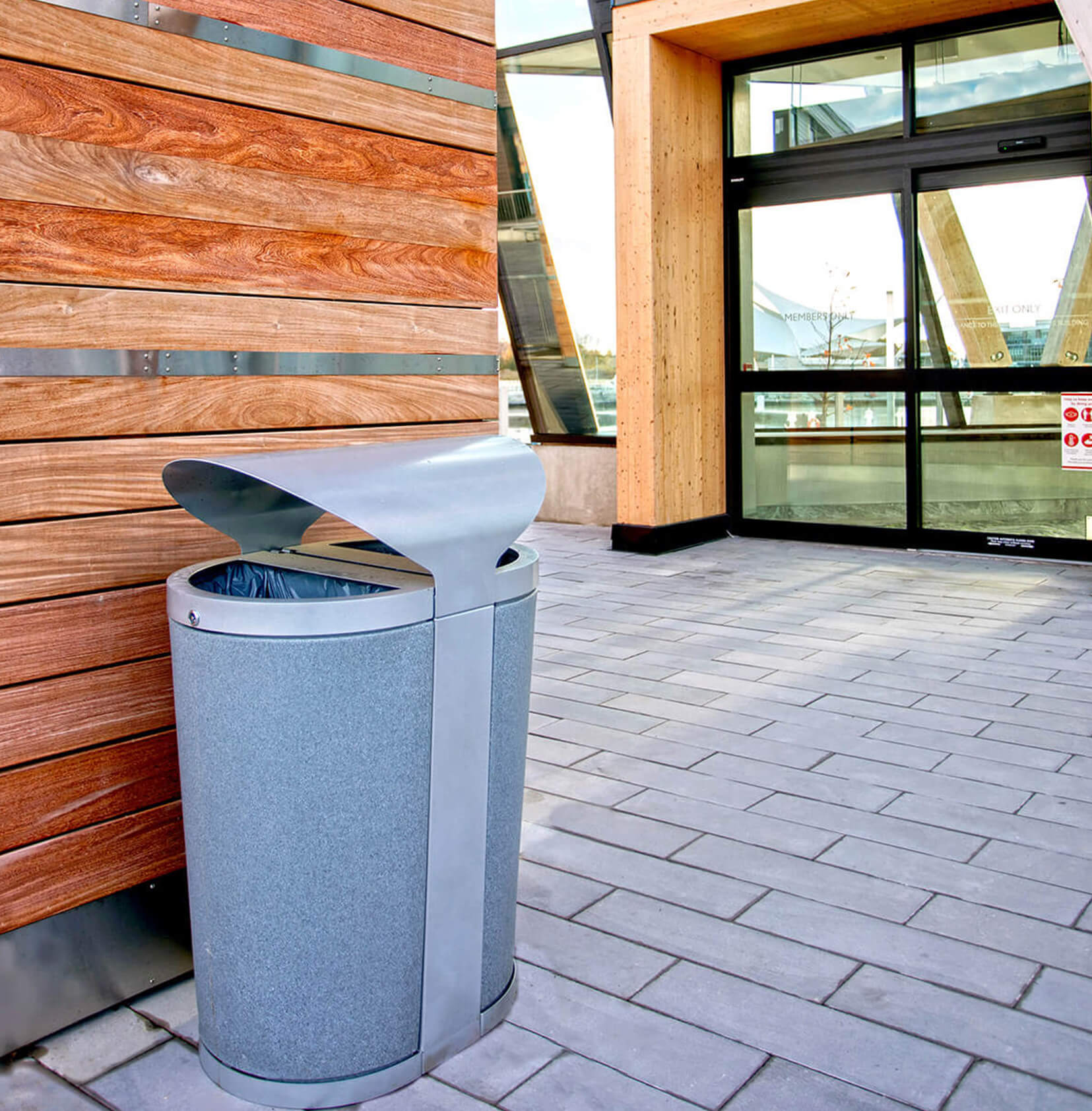 outdoor recycling and trash container at the entrance of a waterfront resort