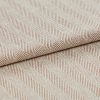 Beige woven herringbone fabric, folded edge across center with diagonal ribbed stripes; showing textured weave in soft light, photographed as a close-up textile sample for upholstery.
