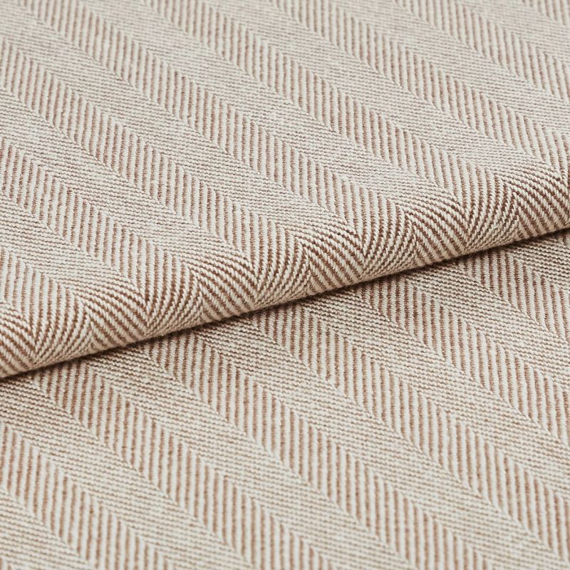 Beige woven herringbone fabric, folded edge across center with diagonal ribbed stripes; showing textured weave in soft light, photographed as a close-up textile sample for upholstery.