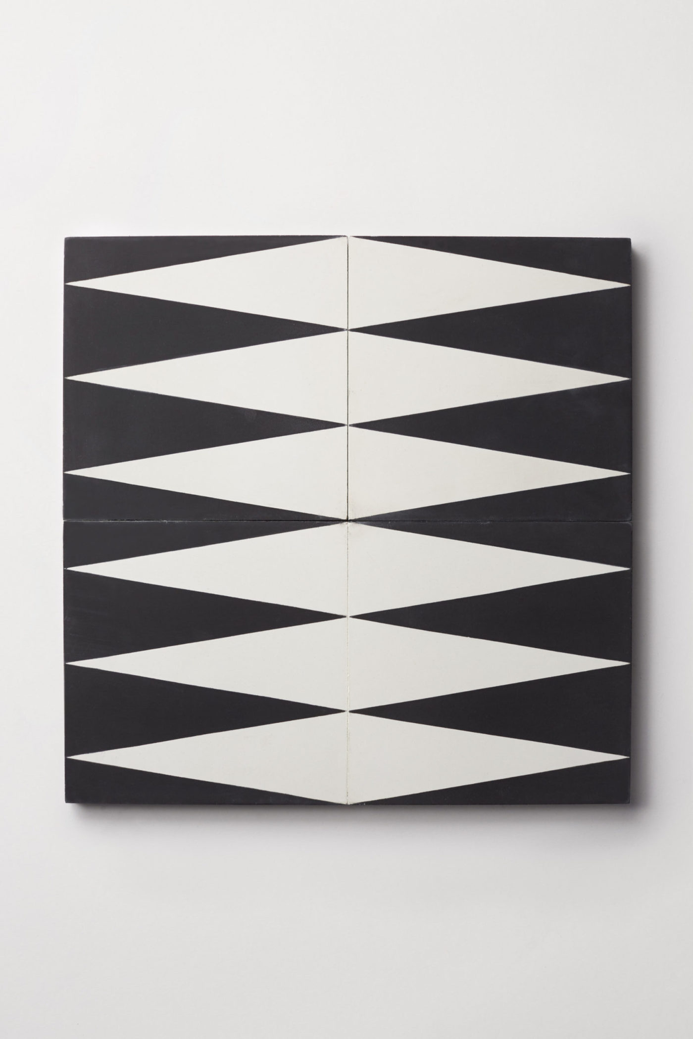 four black and white backgammon patterned tiles on a white surface.