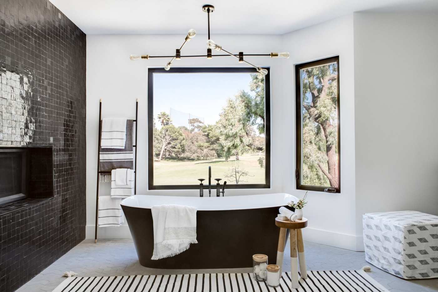 a black and white bathroom with a striped rug.