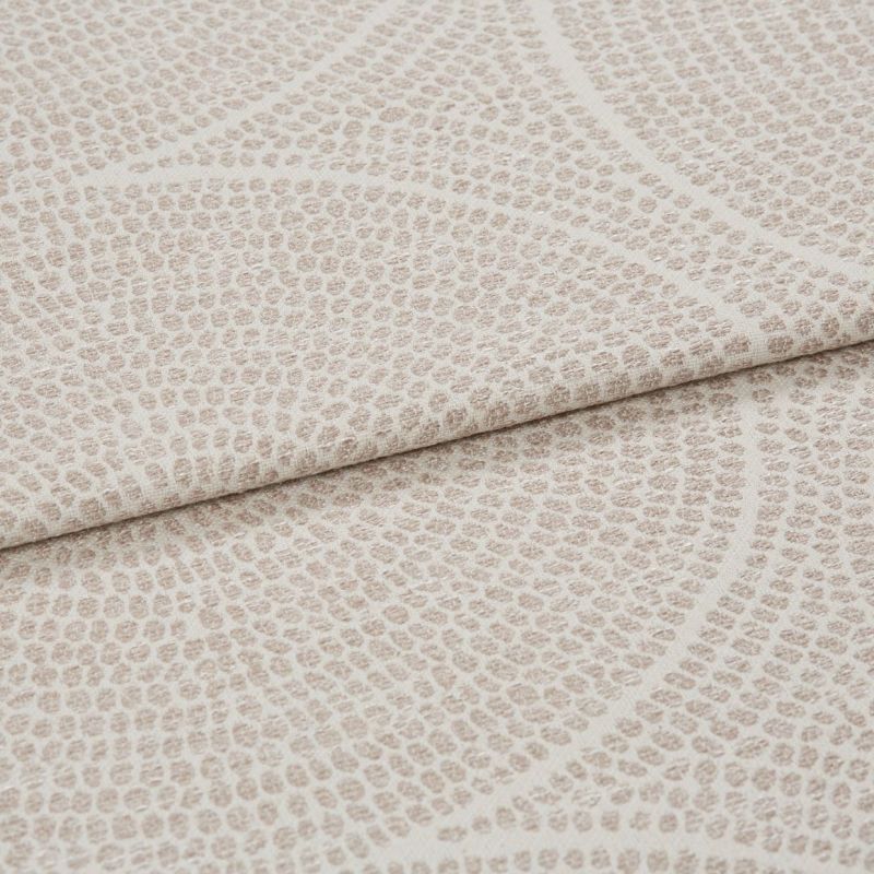 Beige textured fabric with pebbleâ€‘like raised dots and subtle curved lines; folded horizontally across the frame; close-up studio shot showing layered upholstery material in even, soft lighting.