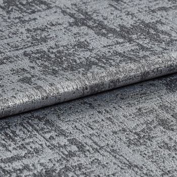 Textured metallic silver fabric folded and layered, its crushed, variegated pile shimmering and reflecting light; close-up studio view with soft lighting and a neutral background.