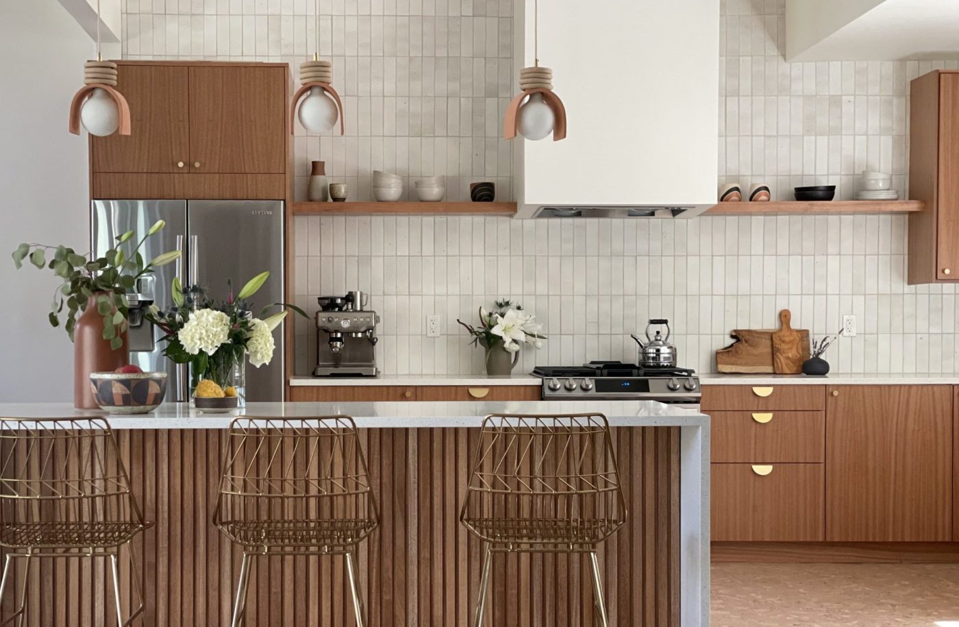 a modern kitchen with wooden cabinets and stools.