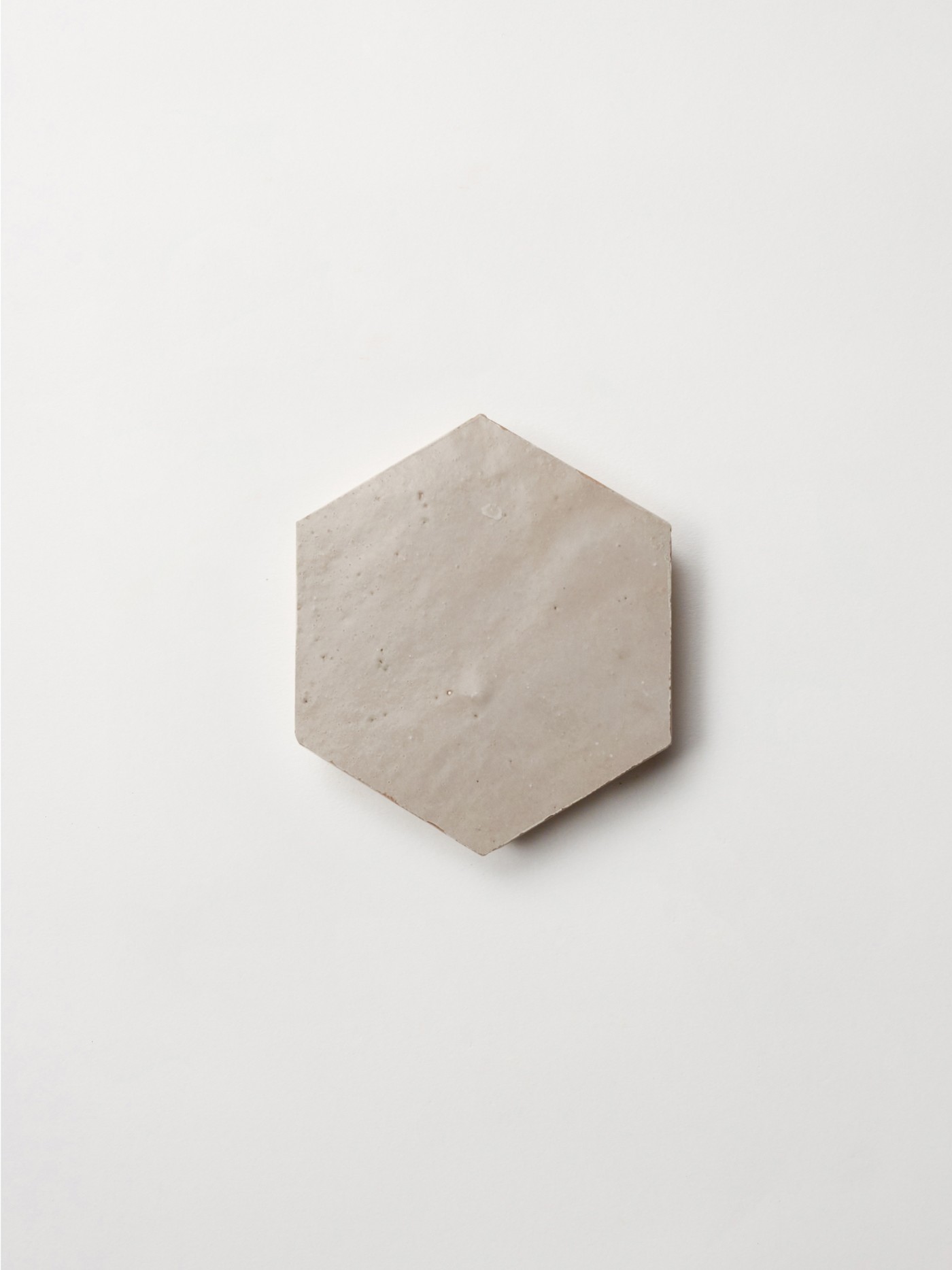 a white hexagonal tile on a white surface.