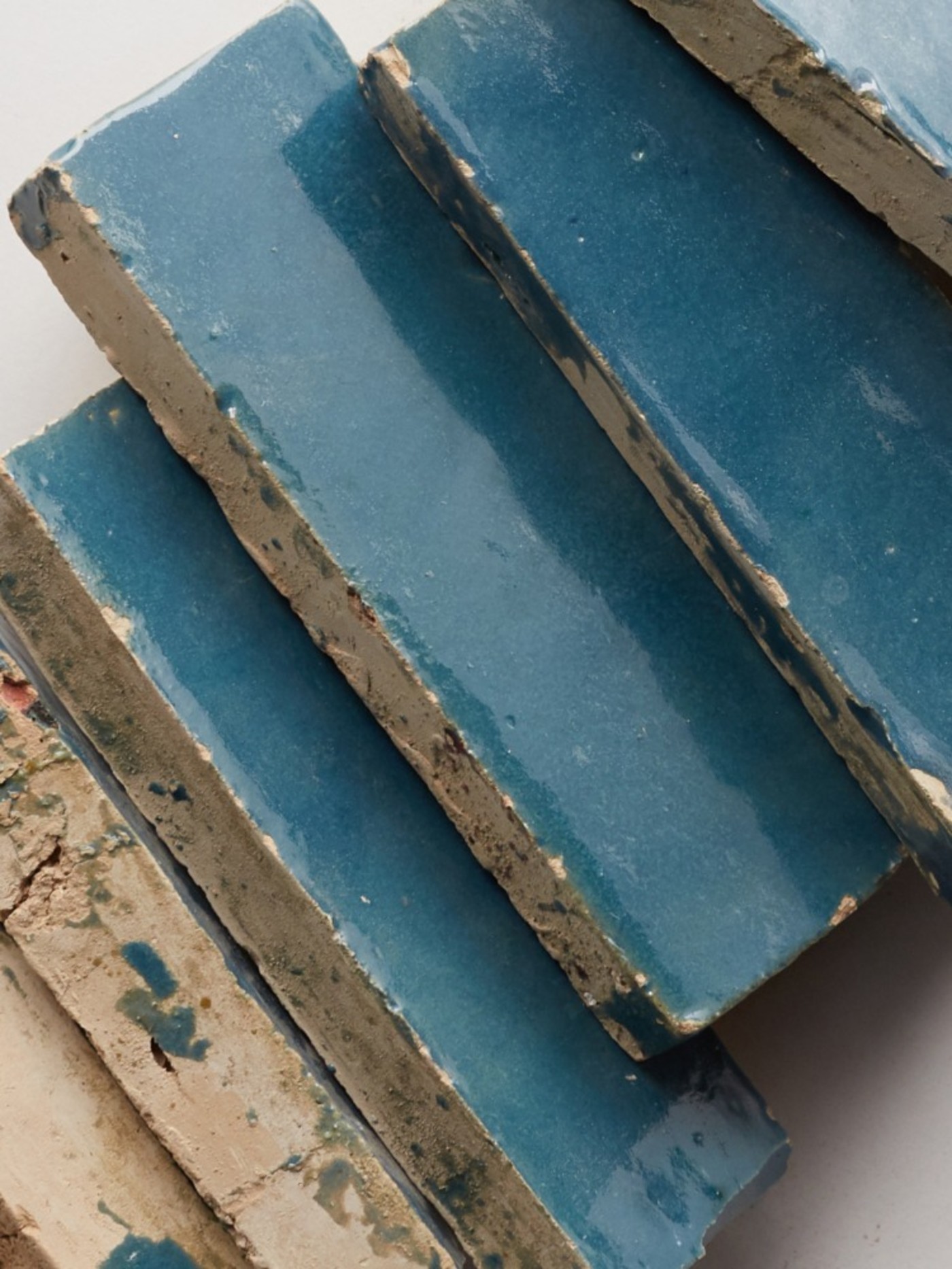 a stack of blue tiles on a white surface.