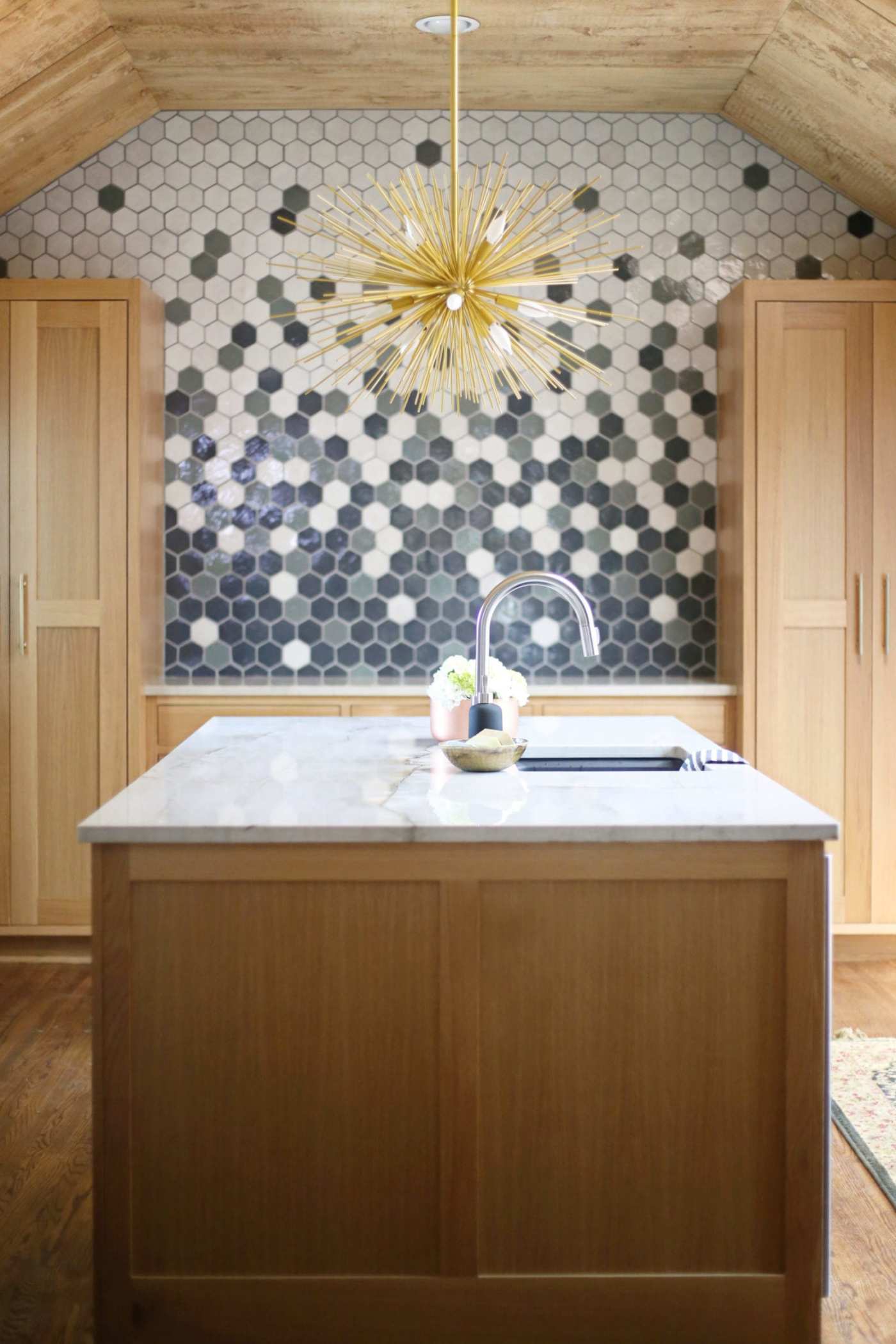 a kitchen with wooden cabinets and a tiled wall.