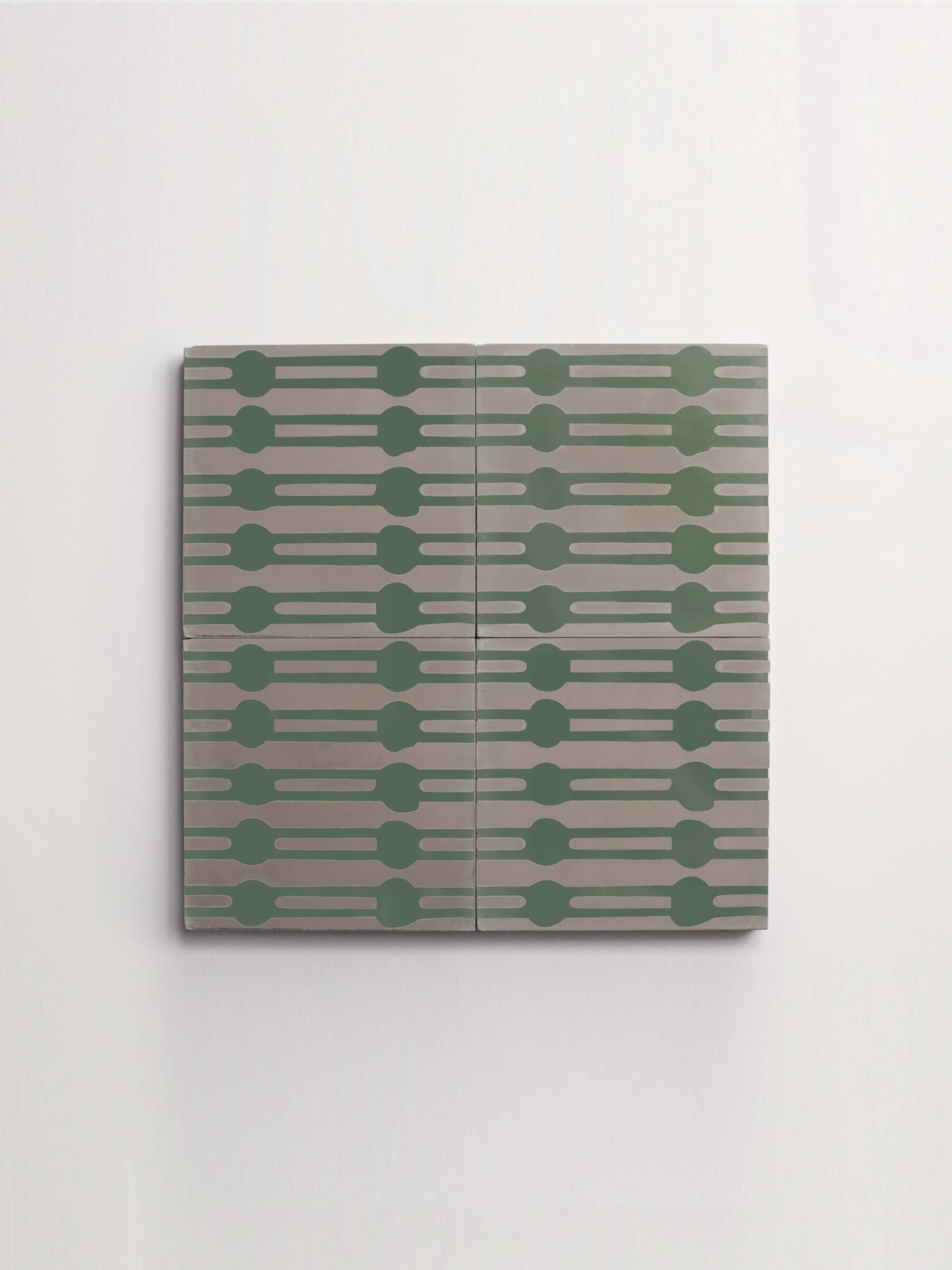 four grey and green tiles hanging on a white background.