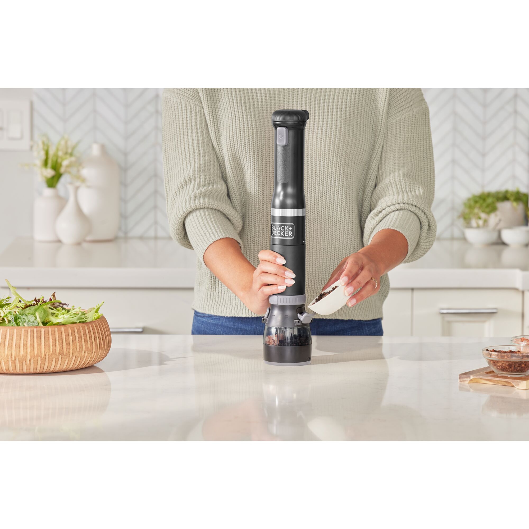 Talent adding peppercorns to the black, BLACK+DECKER kitchen wand spice grinder attachment