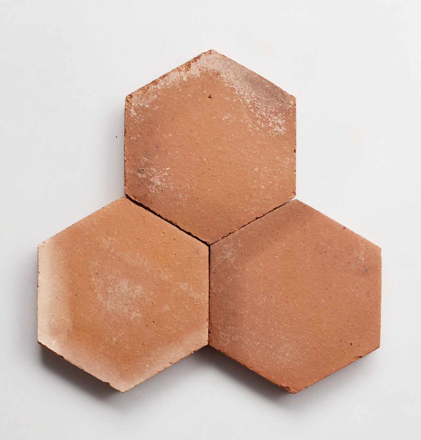 three red hexagonal tiles on a white surface.