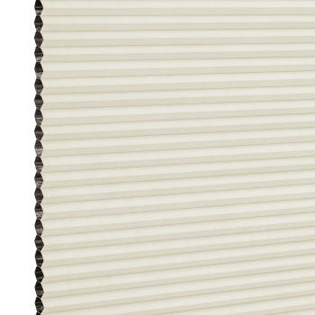 Cream cellular (honeycomb) blind with dark-lined cells visible on the left; closed into uniform horizontal pleats, filtering soft diffuse indoor light against a neutral background.