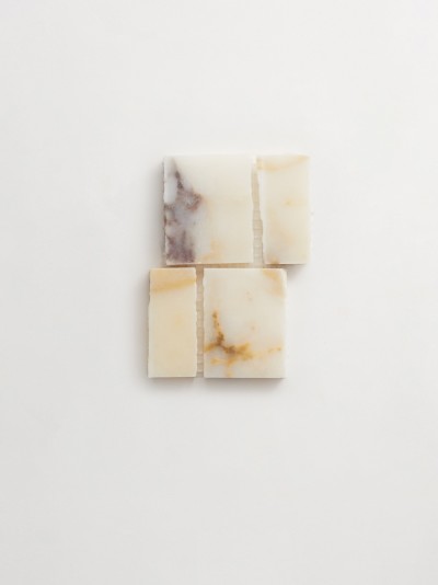 three pieces of soap on a white surface.