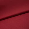 Burgundy satin fabric, folded diagonally with a soft sheen and smooth texture; fold casts a subtle shadow, close-up on a flat surface under even studio lighting.