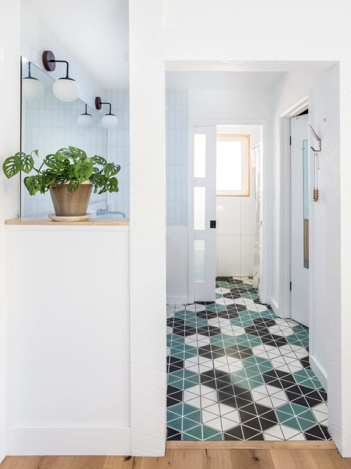 a hallway with a tiled floor and a potted plant.