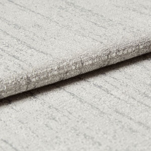 Light-gray textured fabric panel with subtle vertical stripes and stitched horizontal fold — folded over to form a crisp edge — close-up view with soft, even lighting on a neutral surface.