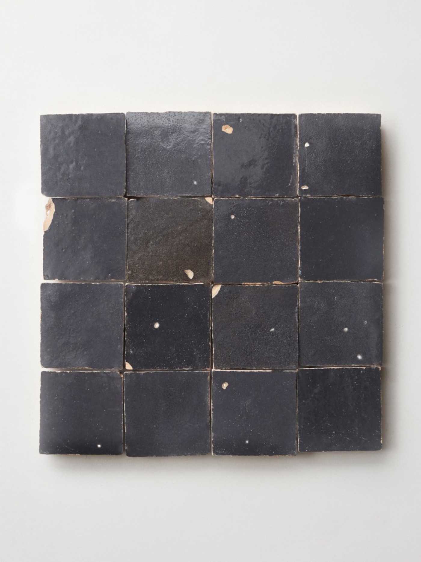 square piece of tile on a white surface.