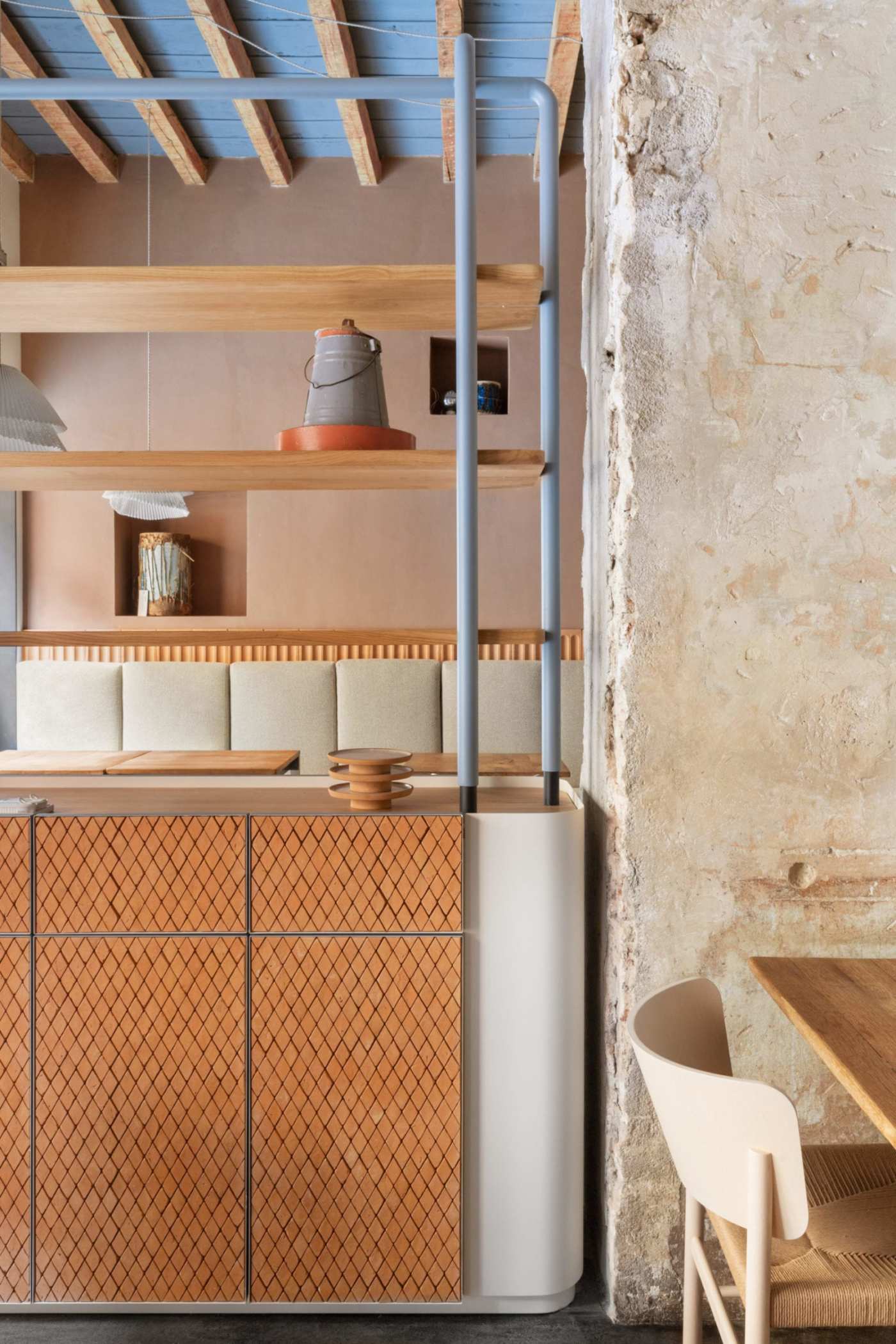 the interior of a restaurant with wooden tables, chairs, and shelves.