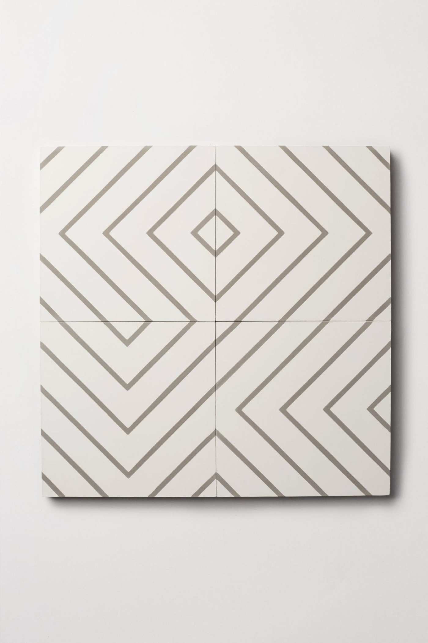 four white and grey tiles on a white surface.