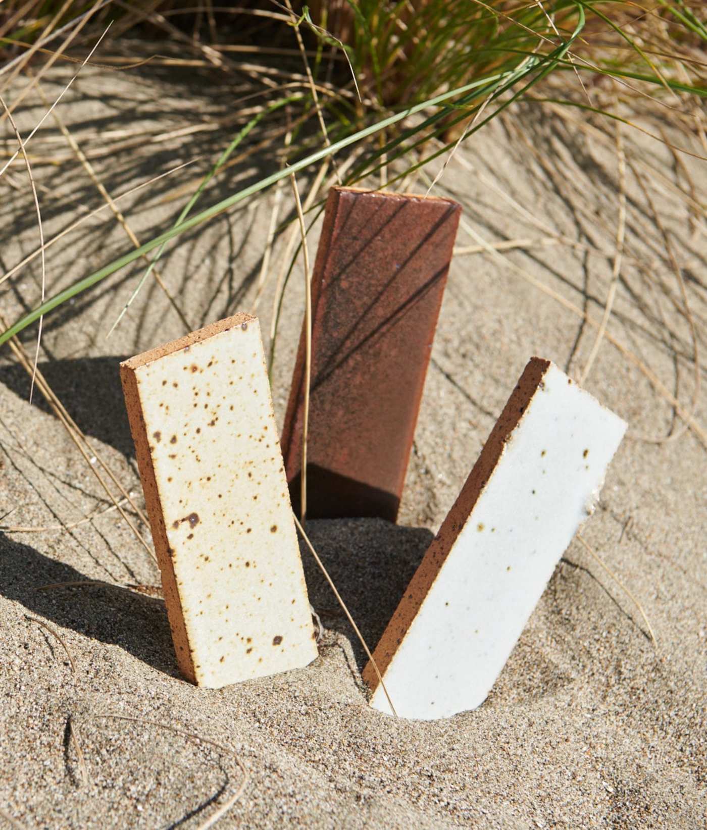 three rectangular tiles sticking out of the sand.