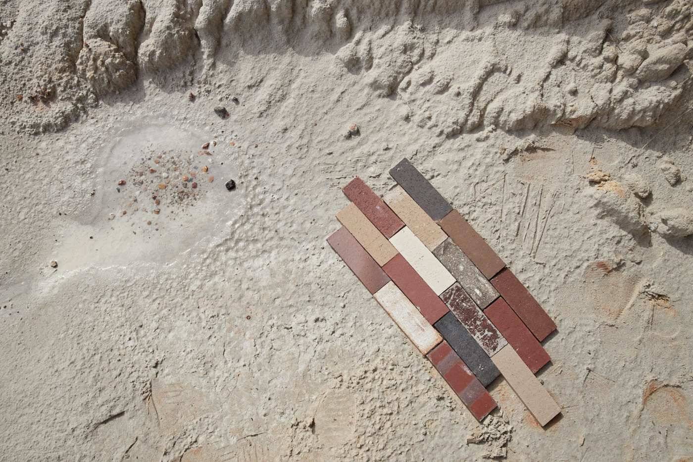 an assortment of multicolored tiles on sandy beach.