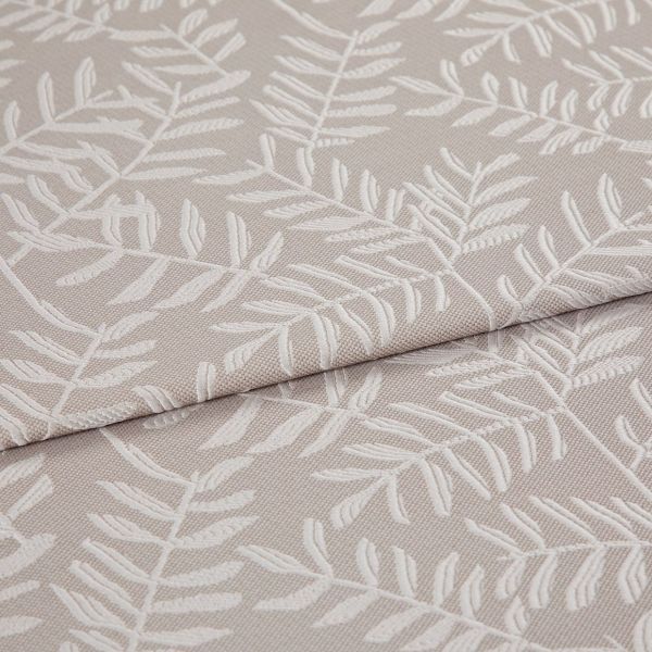 Beige jacquard fabric with raised white fern motif; folded and overlapped; close-up of an upholstery/curtain sample on a flat surface under soft, neutral lighting.