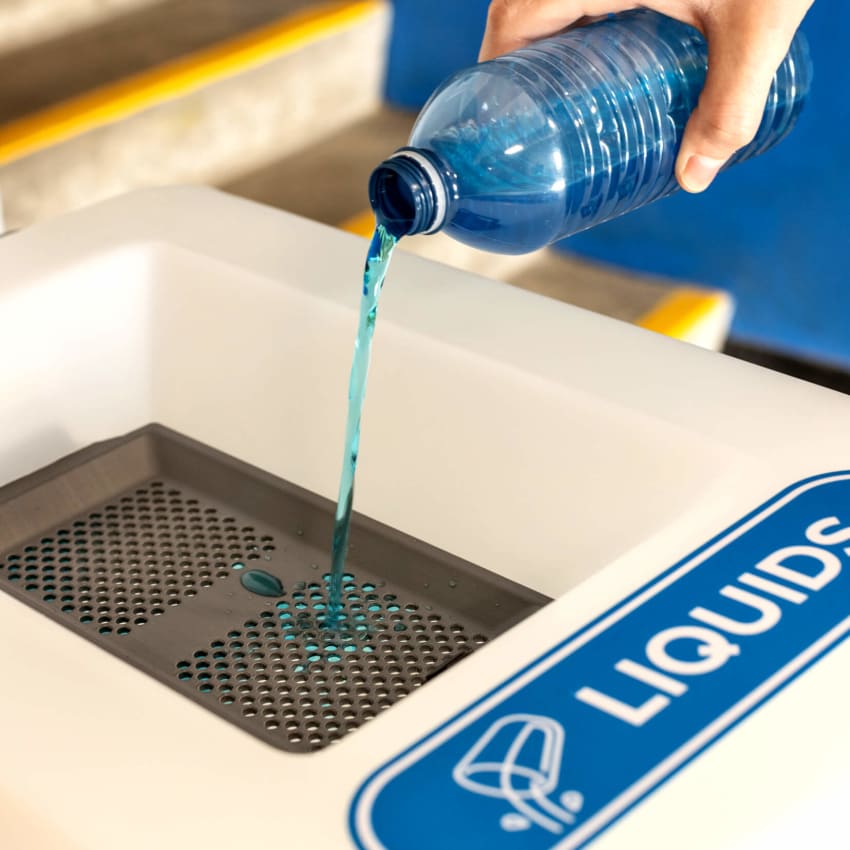 person pouring water into liquid collection station at an arena
