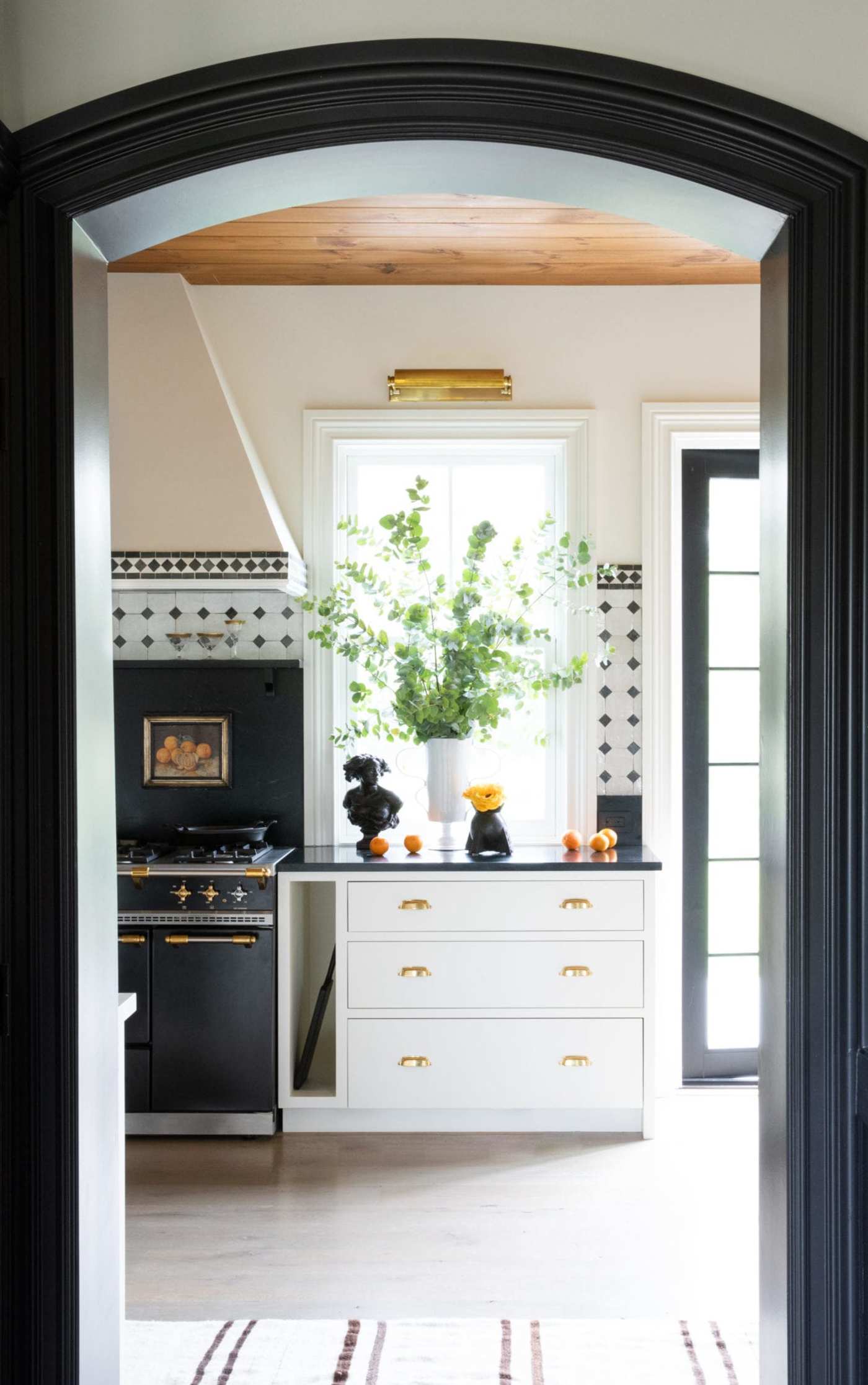 a black and white kitchen with an archway.