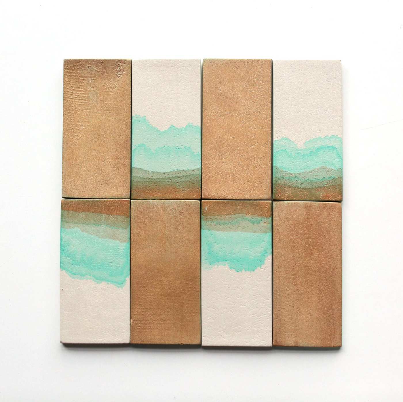 a set of wooden tiles with green and turquoise paint on them.