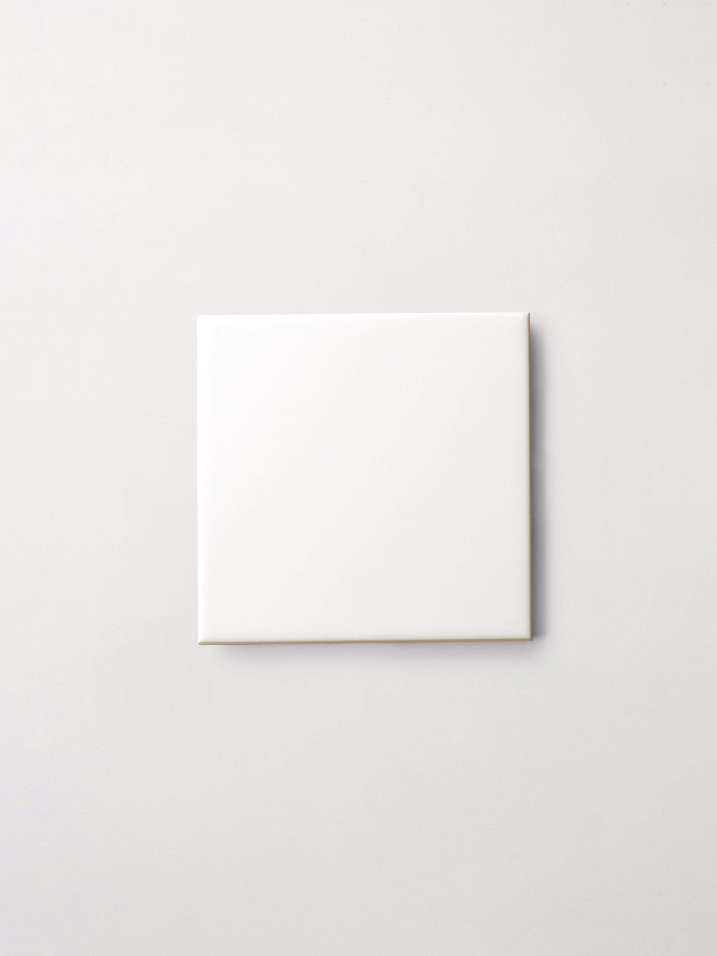 a square white tile on a white surface.