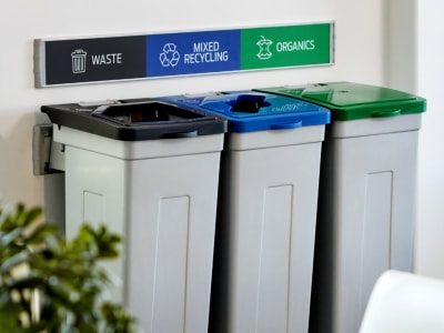 wall hanging trash and recycling containers with brightly colored signs and lids
