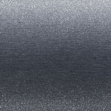 Brushed metallic surface with fine horizontal grain and small bright speckles â€” scattering diffuse light across the plane â€” macro close-up with even, cool-toned lighting, no other features visible.