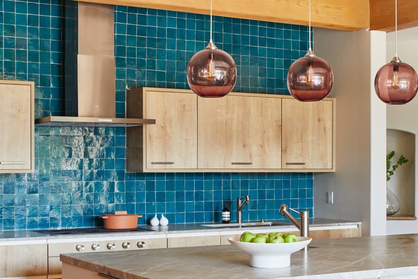 a kitchen with blue tile backsplash and wooden cabinets.