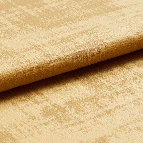 Crushed gold velvet fabric folded along an edge, showing mottled sheen and raised nap; close-up studio view with soft directional lighting.