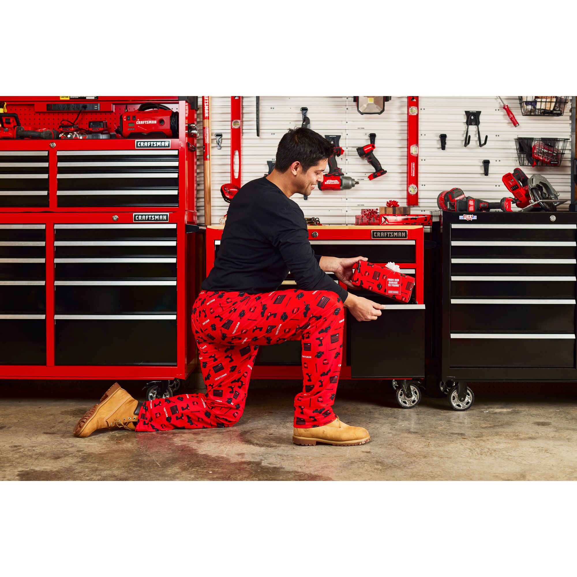 Male in CRAFTSMAN Pajama Pants putting Gift in  drawer