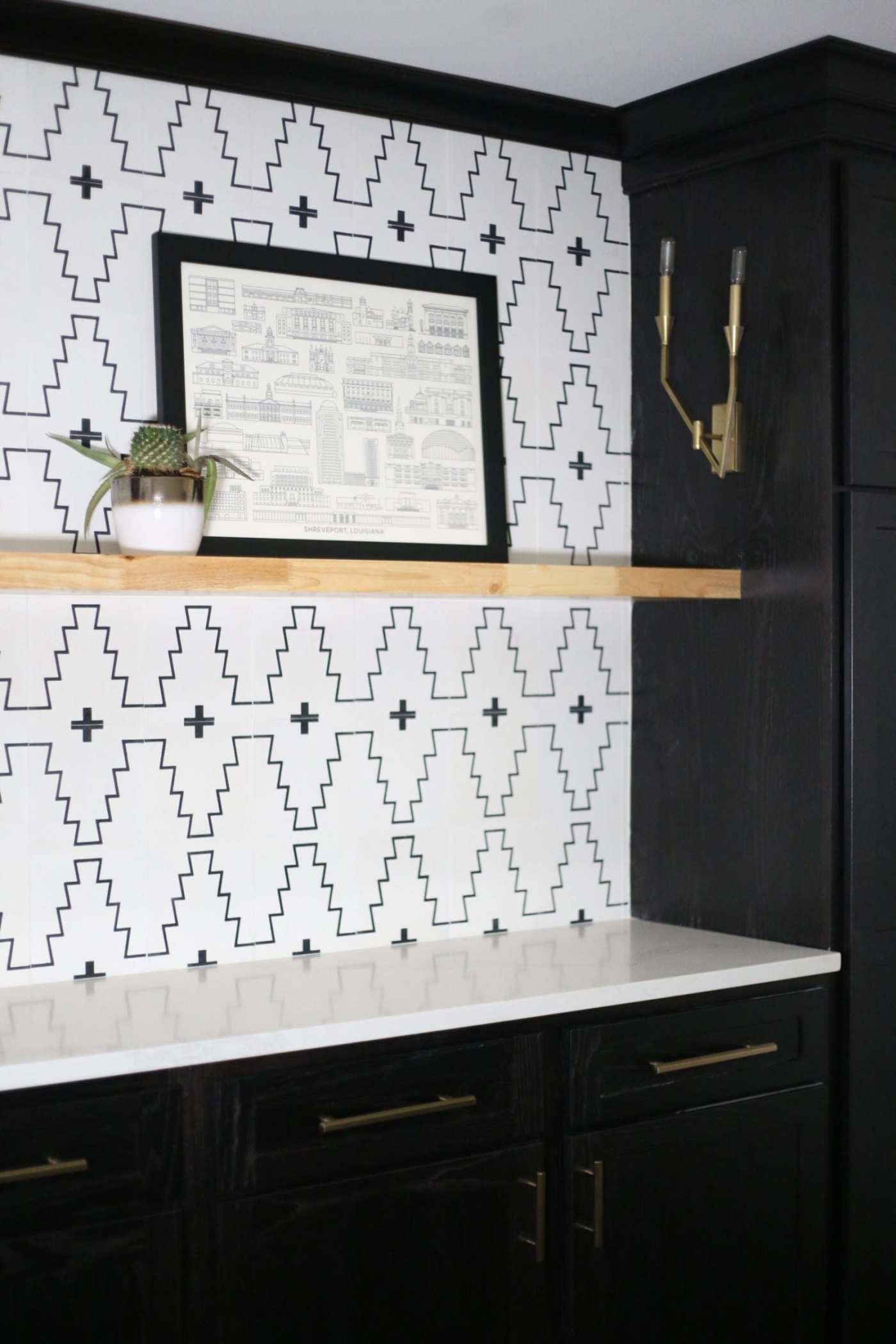 a kitchen with a black and white tile backsplash.