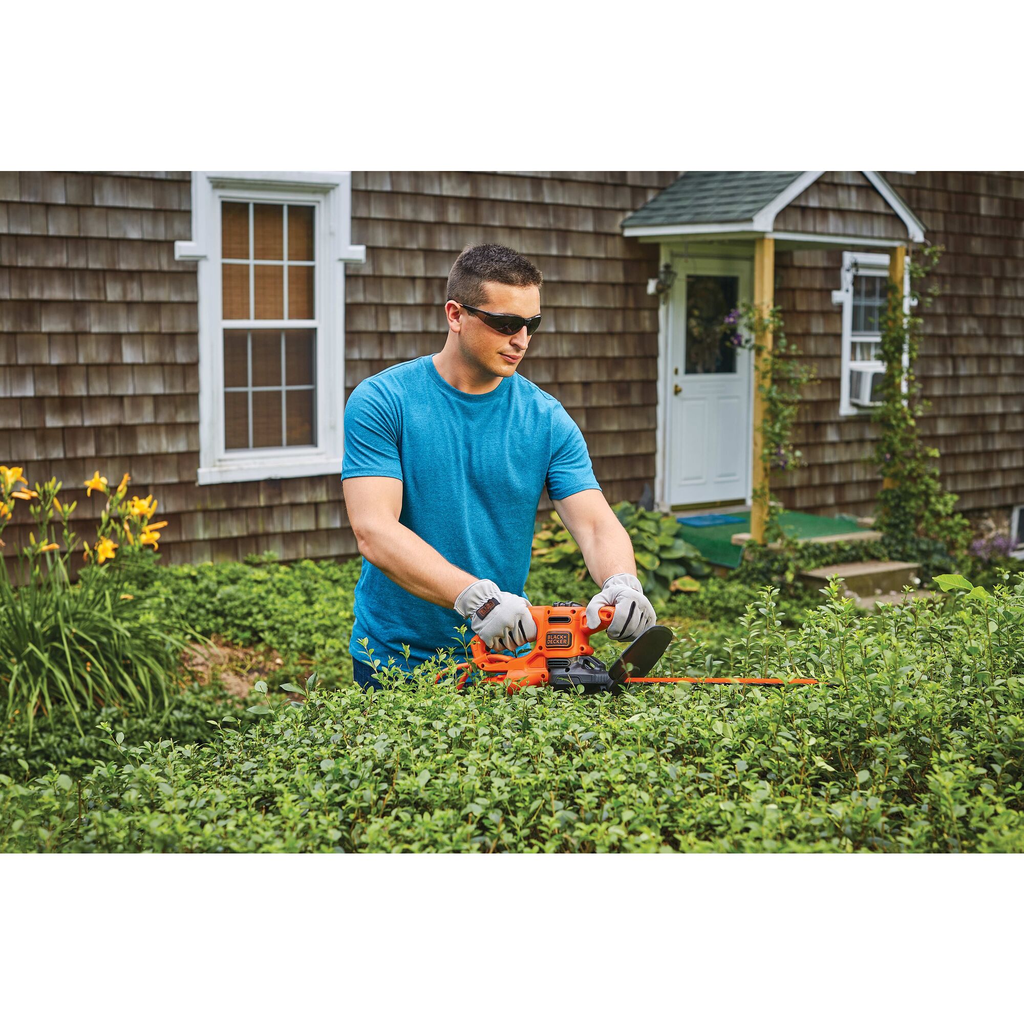 16 inch electric hedge trimmer being used by a person to trim hedge.