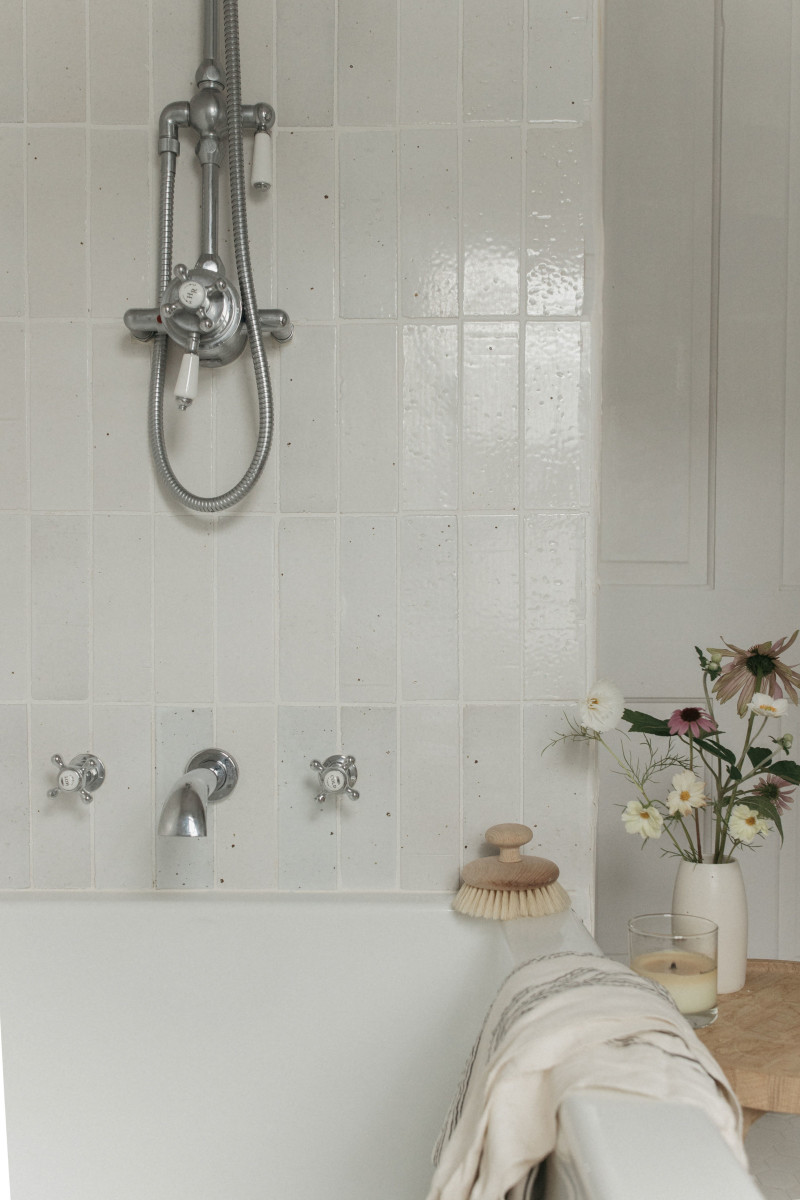 a white bathroom with a white tub and a white towel.